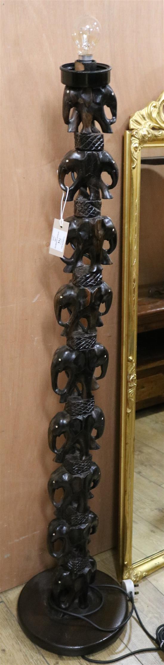 An African carved hardwood standard lamp Width of base 30cm